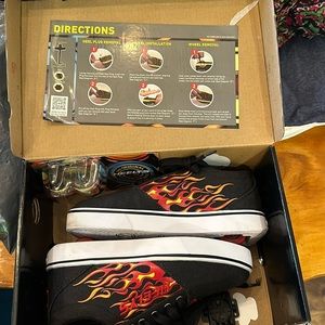 Boys Flame Heelys. Barely used. Still in box. Missing plug removal tool.